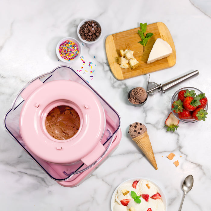Ice cream maker with ingredients and a bowl of ice cream on a marble surface